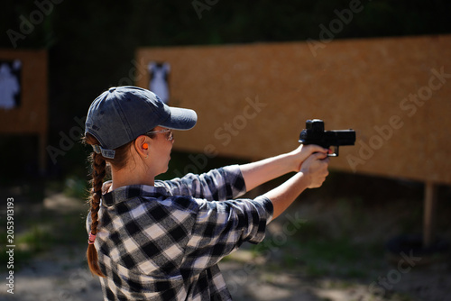 Φωτογραφία Young Woman Practicing Precision Shooting With A Handgun At An Outdoor Target Range In Sunlight