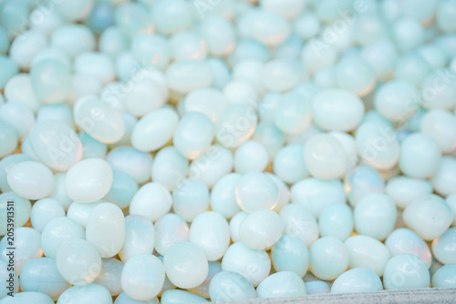Obraz na plátne Abundant Pile Of Smooth Pale Blue Polished moonstone Displayed Under Bright Soft