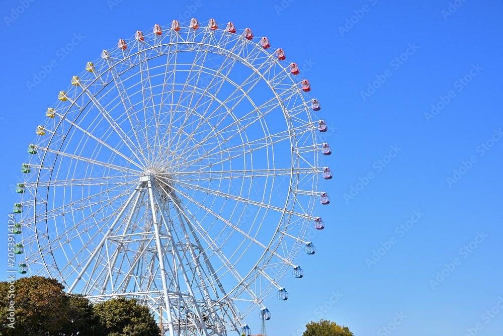 Colorful ferris wheel against a bright blue sky on a sunny day.（観覧車）3