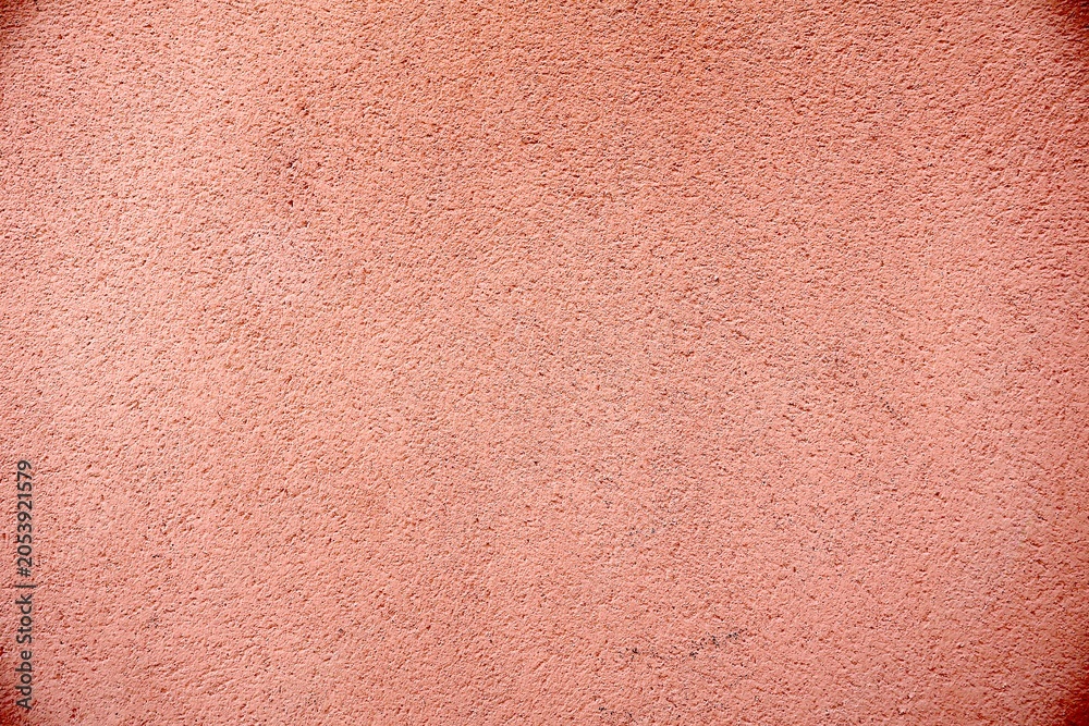 Fototapeta premium Peach-colored granular stucco wall texture.