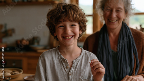 Six year old presents gap-toothed grin to grandmother who holds small tooth pinched between fingers both giggling in warm kitchen lighting first lost tooth celebration milestone