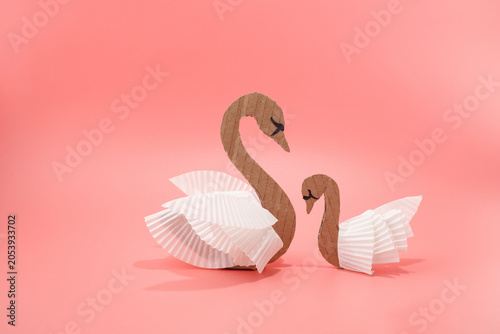 Quadro em tela Cardboard swan and cygnet craft made from corrugated paper and white cupcake liners on pink background