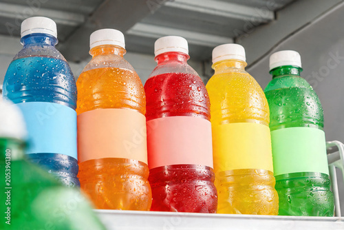 Colorful plastic bottles with blank labels and water droplets