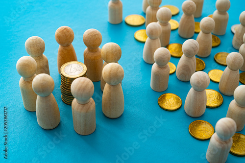 Tableau sur toile Wooden pawns and coins represent protectionism, economic lobbies, competitive markets, and social fragmentation
