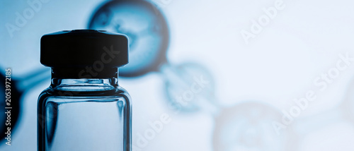 Close-up of a glass vial with a black cap against a bright background with chemical formula silhouettes.
