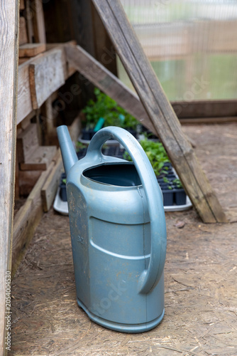 Un arrosoir d'eau de pluie dans un abri, destiné à recueillir l'eau de pluie et pouvoir la réutiliser dans le jardin ou pour ses animaux.