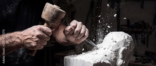 Photography Hands of sculptor working on marble with chisel and hammer creating piece of art