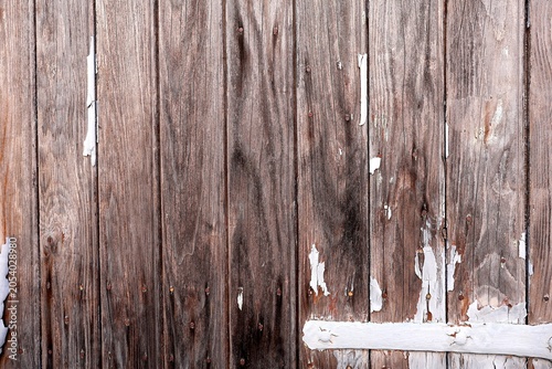 Weathered wooden planks with peeling white paint and rusty nails.