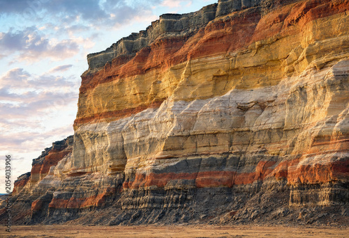 Canvas Print Close up of a steep cliff face showing colorful sedimentary rock layers in shade