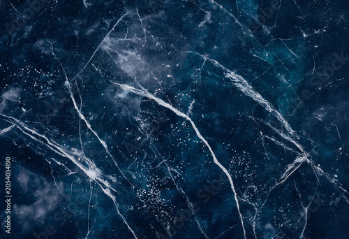 Obraz na plátně Close up of dark blue ice texture with intricate white cracks and frozen air bub