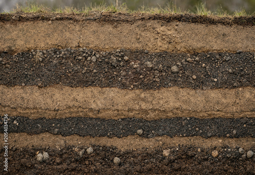 Fotografía Cross section of soil layers showing different textures of earth, gravel, and or