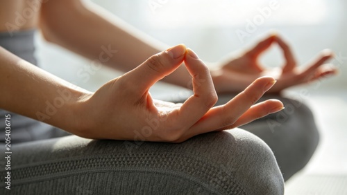 Close up meditation hand gesture during yoga practice with natural sunlight, mindfulness, relaxation and wellness lifestyle concept