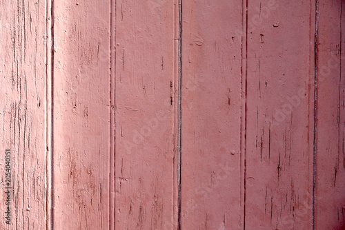 Weathered vertical wooden planks in dusty pink.