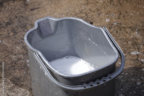 Tableau sur toile Grey bucket containing soapy water for cleaning in outdoor setting