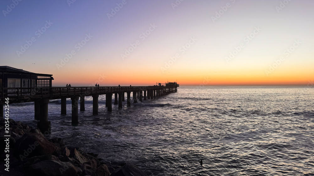 Fototapeta premium Sunset view from the pier in Namibia near the ocean and sandy shore