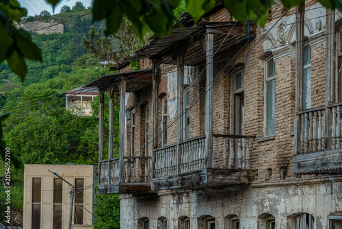 An old abandoned building with a wooden balcony on Dilijan Street