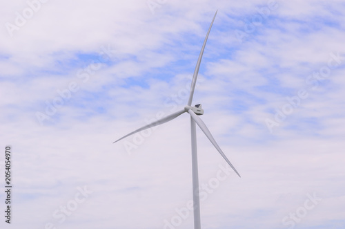A high-quality photograph of modern wind turbines generating clean renewable energy against a beautiful sky. Symbolizing sustainable development, green technology, environmental conservation, and the 
