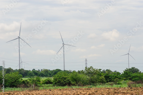 A high-quality photograph of modern wind turbines generating clean renewable energy against a beautiful sky. Symbolizing sustainable development, green technology, environmental conservation, and the 