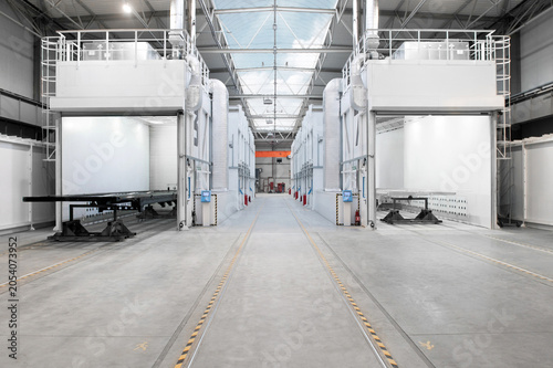 Large industrial paint booths line a clean, spacious facility