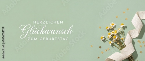 German Happy Birthday Greeting Card featuring chamomile flowers, elegant white ribbon, and gold confetti stars on a sage green background for minimalist holiday wishes, festive banner, and headers.