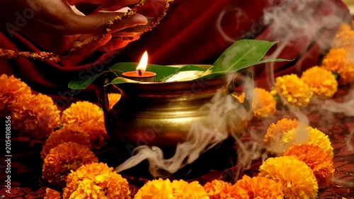 Traditional brass oil lamp with marigold flowers and aromatic incense smoke for religious festival