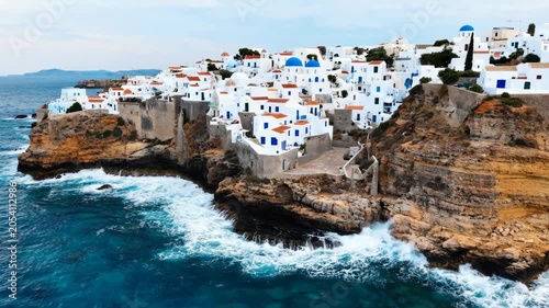 Beautiful white houses with blue domes on a rocky cliff overlooking the blue ocean in greece