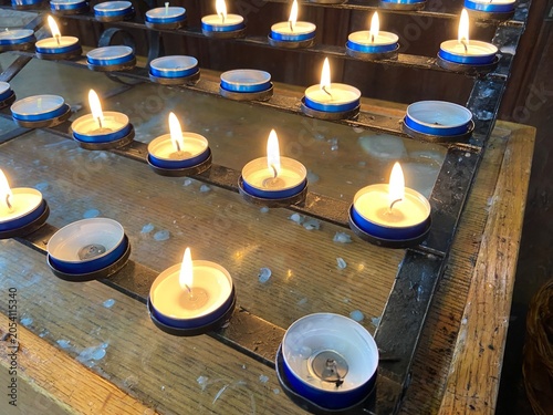 Foto Rows of small candles burning in a church, lit in memory of loved ones
