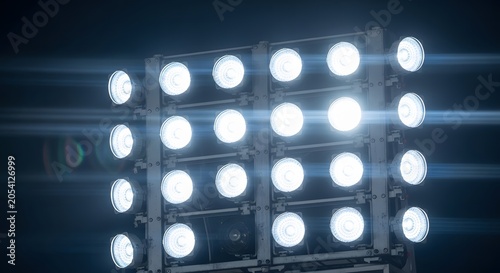 Bright stadium floodlights illuminating a dark blue night sky with powerful beams
