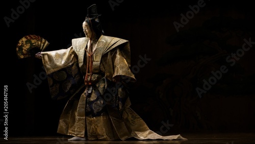  A Noh theater performer in an elaborate costume on stage. 