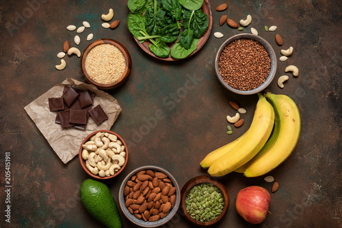 Various food products containing magnesium on dark rustic background, top view, round frame, flat lay, copy space