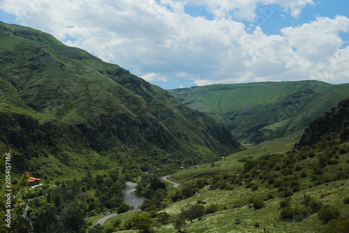 Tableau sur toile Green mountain valley with winding river landscape