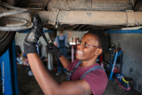 Foto Confident Young Female Mechanic Fixing Car in Auto Repair Shop