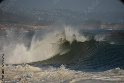 Giant shorebreak crashing on the sand at the wedge
