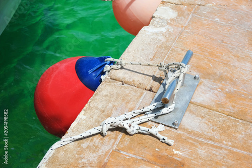 Buoy secured to dock with rope.