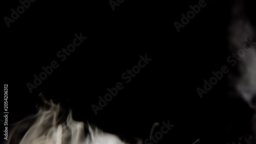Abstract white smoke swirling and rising against a black background for cinematic visual effects and overlays