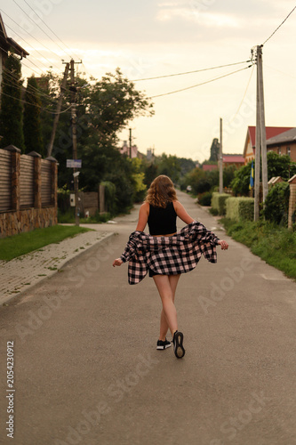 Joyful millennial girl enjoying a warm summer evening in a cozy neighborhood