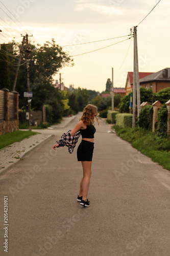 Joyful millennial girl enjoying a warm summer evening in a cozy neighborhood