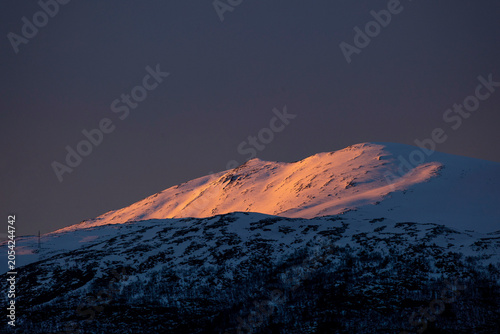 Beautiful golden sunlight shining on snowy mountain peaks. A springtime scenery near Geiranger Unesco World heritage area, Sunnmore, More og Romsdale, Norway.