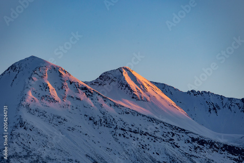 Beautiful golden sunlight shining on snowy mountain peaks. A springtime scenery near Geiranger Unesco World heritage area, Sunnmore, More og Romsdale, Norway.