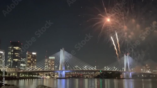 Tilikum crossing bridge in portland, oregon at night with fireworks display over the willamette river