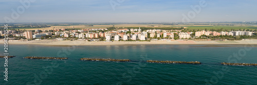 Panorama shot of sandy beach with umbrellas and gazebos.Summer vacation concept.Lido Adriano town,Adriatic coast, Emilia Romagna,Italy.