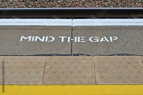 Painted Safety Sign on Edge of Railway Station Platform 'Mind The Gap' 
