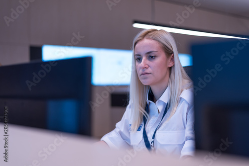 Focused Young Female Security Officer Working in Surveillance Control Room