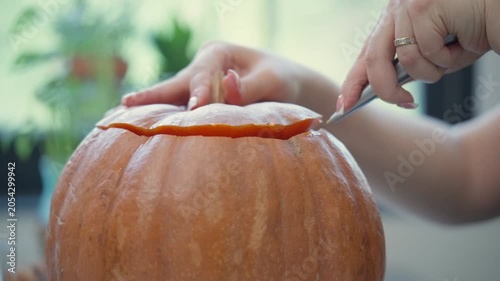 Hands removing pumpkin lid and revealing seeds inside