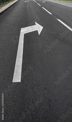 Road surface with white arrow marking indicating right turn direction