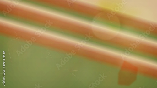 Blurry orange tubes on green background with light effect