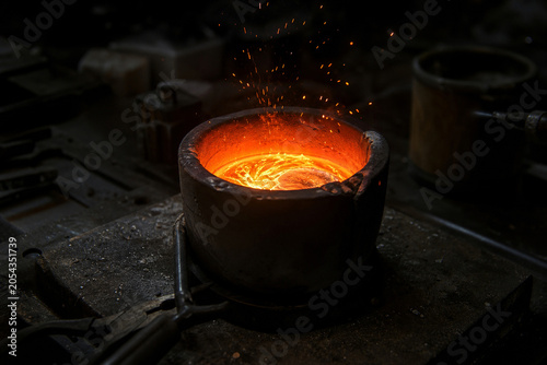 Molten metal glowing brightly with flying sparks.