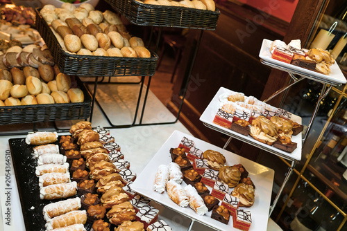 Quadro su tela Assorted pastries and baked goods displayed on tiered trays in bakery