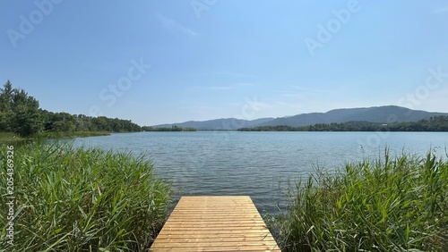 Pasarela de madera en una gran lago rodeado de montañas