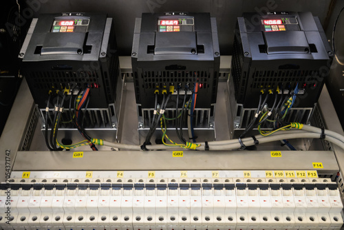 Bild auf Leinwand Three variable frequency drives with digital displays mounted over circuit break